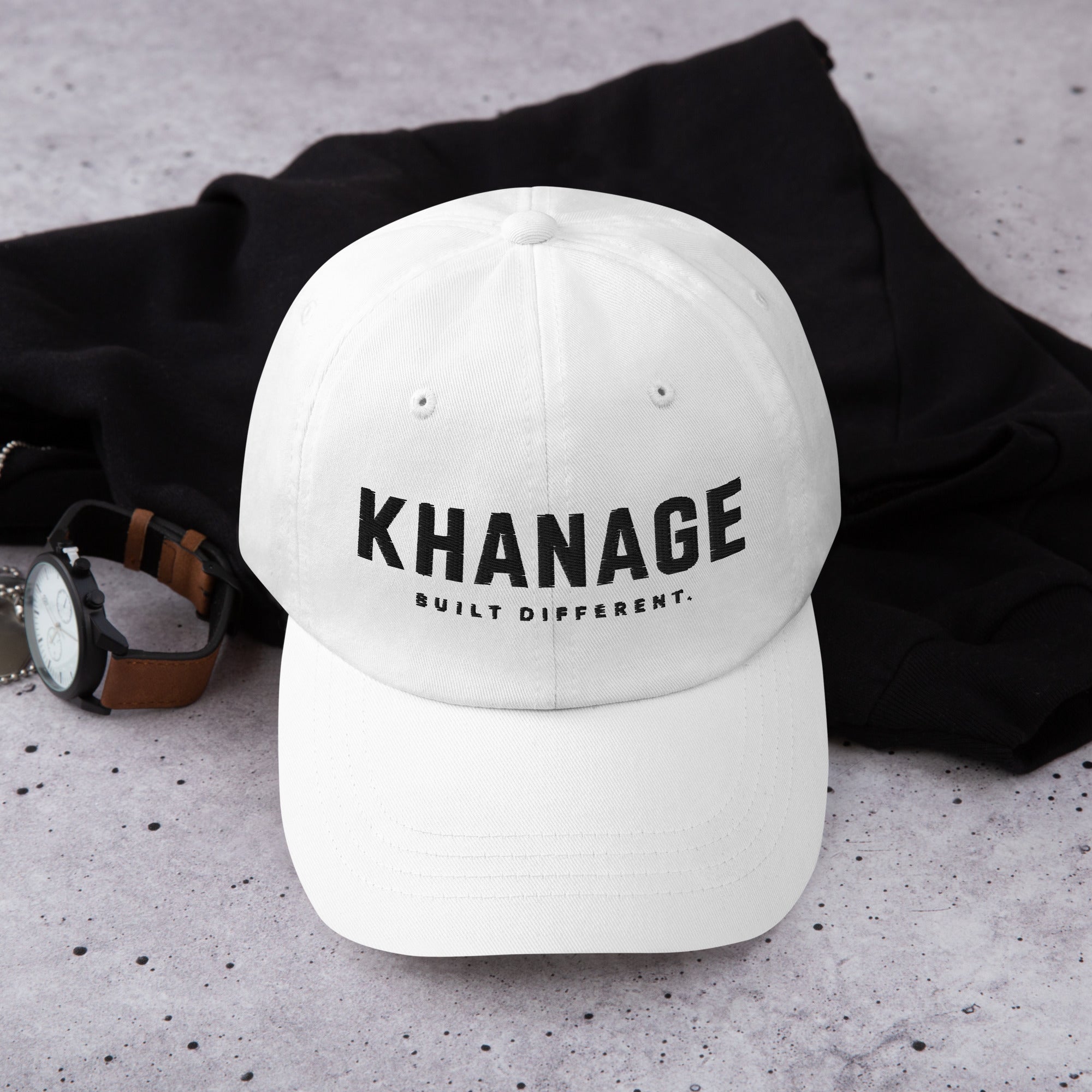 Front view of KHANAGE Built Different signature embroidered cap in White